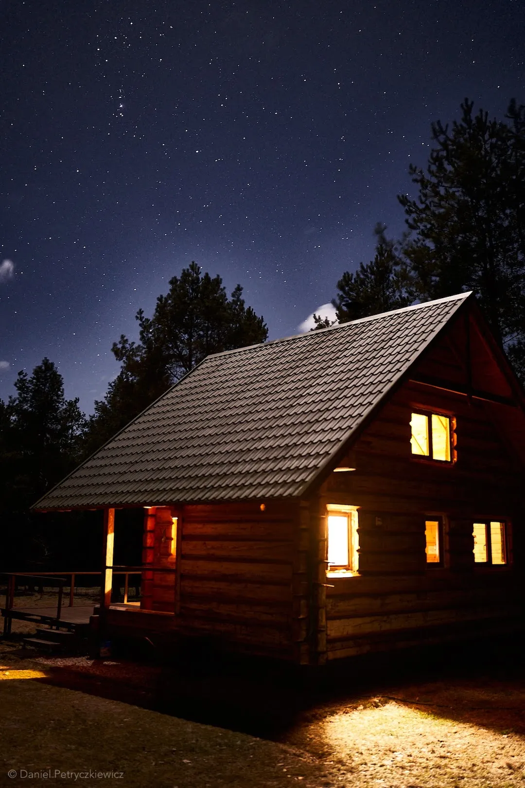 Piętrowy dom z oświetlonymi oknami nocą