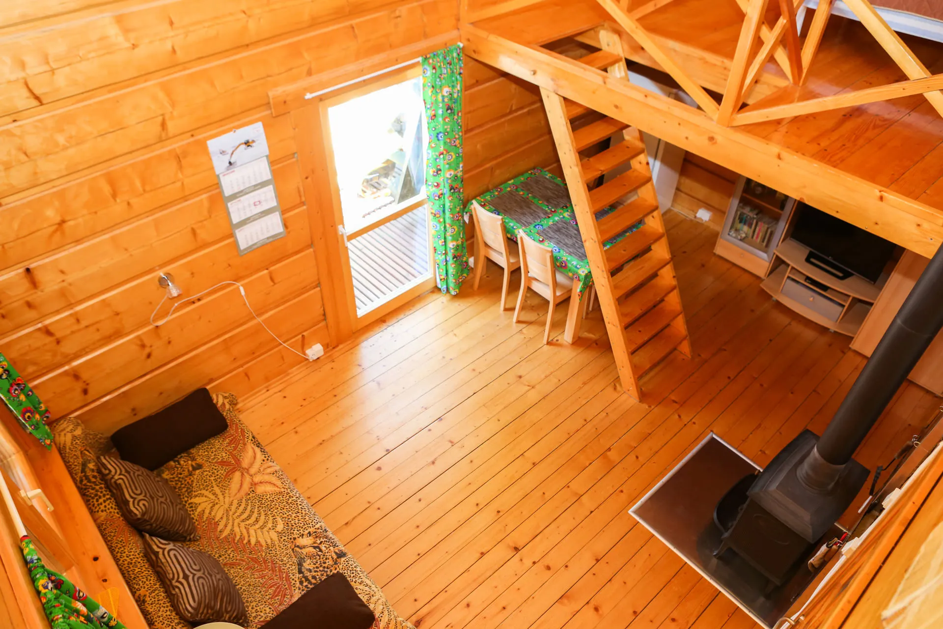 Widok z antresoli na salon z jadalnią i piecem